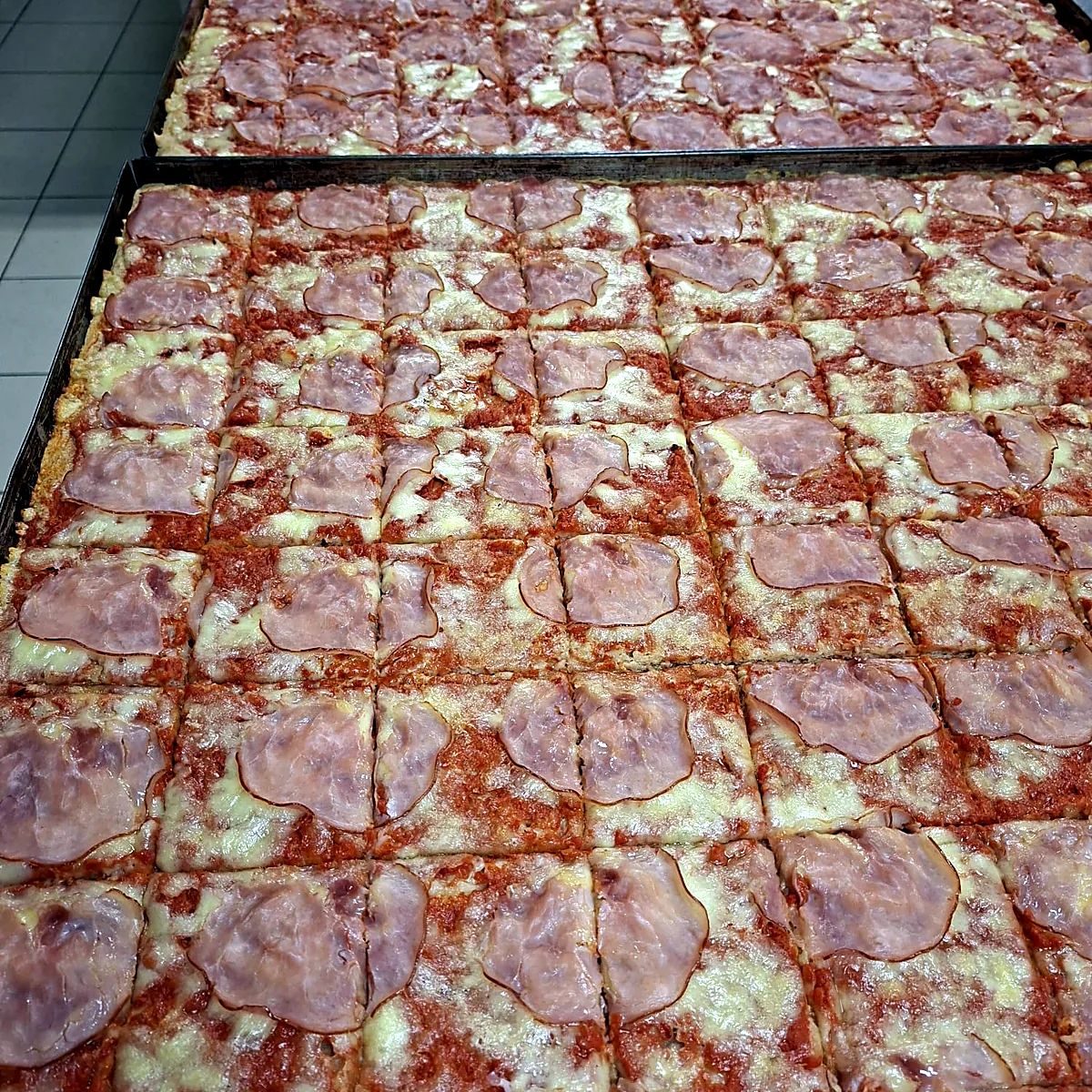 Pizzablech frisch aus dem Ofen, in Stücke geschnitten